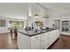 Stylish kitchen with large island, white cabinets, stainless appliances, granite counters, and hardwood floors at 7605 E Windlawn Way, Parker, CO 80134