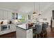 Bright kitchen with large island, white cabinets, granite counters, stainless appliances, and hardwood floors at 7605 E Windlawn Way, Parker, CO 80134