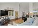 Spacious living area featuring hardwood floors, neutral furniture, and an open flow into the kitchen at 7605 E Windlawn Way, Parker, CO 80134