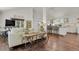 Open-concept living room featuring hardwood floors flowing into a bright, white kitchen with bar seating at 7605 E Windlawn Way, Parker, CO 80134