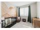 Bedroom with mountain mural, dark crib, plush chair, and matching wooden dresser at 10088 E 62Nd Ave, Denver, CO 80238