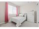 Cozy bedroom features a white bed with decorative pillows and bright pink curtains at 10088 E 62Nd Ave, Denver, CO 80238