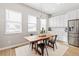 Bright dining area with a wooden table, modern lighting, and lots of natural light from the windows at 10088 E 62Nd Ave, Denver, CO 80238