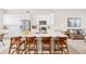 Modern kitchen featuring a large island, white cabinets, stainless steel appliances and stylish pendant lighting at 10088 E 62Nd Ave, Denver, CO 80238