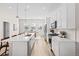 Bright, modern kitchen with stainless appliances, white cabinets, and a quartz-topped island with seating at 10088 E 62Nd Ave, Denver, CO 80238