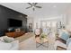 Open-concept living room featuring modern furniture, a ceiling fan, and seamless flow into the kitchen at 10088 E 62Nd Ave, Denver, CO 80238