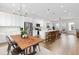 Open concept kitchen with stainless steel appliances, wooden dining table, and bright living area at 10088 E 62Nd Ave, Denver, CO 80238