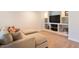 Cozy basement area with a comfortable sectional sofa and built-in shelving for entertainment at 2214 E 101St Ave, Thornton, CO 80229