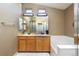Modern bathroom with double sinks, spacious vanity, soaking tub and shower, and bright lighting at 2214 E 101St Ave, Thornton, CO 80229
