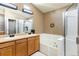 Well-lit bathroom featuring a double vanity, soaking tub, and a glass-enclosed shower for a spa-like experience at 2214 E 101St Ave, Thornton, CO 80229