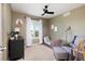 Well-appointed bedroom with a comfortable seating area, neutral tones, and plenty of natural light from the shuttered window at 2214 E 101St Ave, Thornton, CO 80229