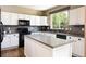 Bright kitchen with white cabinets, dark appliances, and a functional center island at 2214 E 101St Ave, Thornton, CO 80229