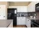 Well-equipped kitchen with black appliances, white cabinetry, and ample counter space at 2214 E 101St Ave, Thornton, CO 80229