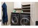 Well-equipped laundry room featuring modern washer and dryer with convenient overhead storage and sleek countertop at 2214 E 101St Ave, Thornton, CO 80229