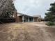 Spacious backyard featuring a brick home exterior, patio, and mature trees at 11306 E Colorado Dr, Aurora, CO 80012