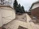View of shed, brick home, and mature trees in the backyard at 11306 E Colorado Dr, Aurora, CO 80012