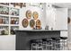Finished basement featuring an elegant home bar with four stools and a display of bottles at 2404 Horse Shoe Cir, Fort Lupton, CO 80621