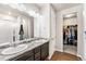 Well-lit bathroom with double sinks and a walk-in closet, perfect for organization at 2404 Horse Shoe Cir, Fort Lupton, CO 80621