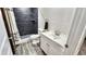 Bathroom featuring a dark tiled shower, white vanity, and modern fixtures at 2404 Horse Shoe Cir, Fort Lupton, CO 80621