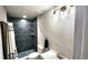 Modern bathroom featuring a dark tiled shower, sleek vanity, and modern fixtures at 2404 Horse Shoe Cir, Fort Lupton, CO 80621