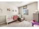 Charming bedroom with a crib, recliner, and playful decor at 2404 Horse Shoe Cir, Fort Lupton, CO 80621