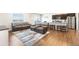 Open-concept living room with an adjacent kitchen, plush sofas, and hardwood floors at 2404 Horse Shoe Cir, Fort Lupton, CO 80621