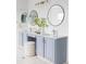 Bathroom featuring double sinks, granite countertops, soft blue cabinetry, and modern round mirrors at 674 Huntington Dr, Highlands Ranch, CO 80126