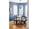 A light-filled dining area with stylish furnishings, complemented by a modern chandelier and blue accent wall at 674 Huntington Dr, Highlands Ranch, CO 80126