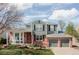 Charming two-story home featuring a manicured lawn, brick accents, and an attached two-car garage at 674 Huntington Dr, Highlands Ranch, CO 80126