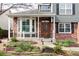 Inviting covered front porch with decorative brickwork and lush landscaping at 674 Huntington Dr, Highlands Ranch, CO 80126