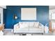 A stylish living room featuring a white sofa, modern decor, a gold lamp, and a textured accent wall at 674 Huntington Dr, Highlands Ranch, CO 80126