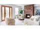 A comfortable living room featuring a brick fireplace, natural light, plush seating, and an open layout at 674 Huntington Dr, Highlands Ranch, CO 80126