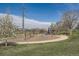 A colorful community playground features swings, slides, and climbing structures amidst mature trees and walking paths at 1087 Wolff St, Denver, CO 80204