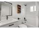 Bright bathroom featuring a shower and tub combination, white tiles, dark fixtures, and modern vanity with storage at 3545 Moorhead Ave, Boulder, CO 80305