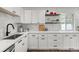 Bright kitchen featuring white cabinets, sleek counter tops and stylish backsplash with modern fixtures at 3545 Moorhead Ave, Boulder, CO 80305