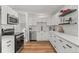 Bright kitchen featuring white cabinets, stainless steel appliances, stylish backsplash, and wood floors at 3545 Moorhead Ave, Boulder, CO 80305