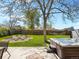 Spacious backyard showcasing a hot tub, fire pit area, a lush lawn, and mature tree at 4779 S Owens Way, Littleton, CO 80127
