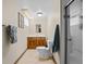 Cozy bathroom featuring neutral tiling, a glass door shower, wood vanity and framed mirror at 4779 S Owens Way, Littleton, CO 80127