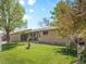 Charming single-story home featuring a well-maintained lawn, mature trees and an attached two-car garage at 4779 S Owens Way, Littleton, CO 80127