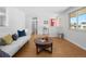 Bright living room with wood floors, white walls, and a red front door at 4779 S Owens Way, Littleton, CO 80127
