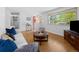 Comfortable living room features stylish hardwood floors, a large window, and an inviting white sofa with blue pillows at 4779 S Owens Way, Littleton, CO 80127