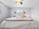 Bright main bedroom features a ceiling fan, a light-colored wooden headboard, and a cozy blanket at 4779 S Owens Way, Littleton, CO 80127