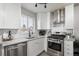 Modern kitchen with white cabinets, stainless steel appliances, and subway tile backsplash at 2686 Poplar St, Denver, CO 80207