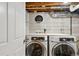 Basement laundry room with washer, dryer, and ample storage shelving at 2686 Poplar St, Denver, CO 80207