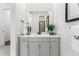 Well-lit bathroom with a white cabinet, quartz countertop, and a large mirror at 16655 W 93Rd Pl, Arvada, CO 80007