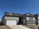 New construction home with stone accents and a two-car garage with gray horizontal siding under a dark roof at 16655 W 93Rd Pl, Arvada, CO 80007
