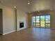 Bright living room with a modern fireplace, large windows, and a sliding glass door to the outdoor space at 16655 W 93Rd Pl, Arvada, CO 80007
