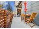 Cozy back patio with wooden table and chairs, an orange umbrella, and a well-maintained fence at 1857 W 67Th Pl, Denver, CO 80221
