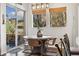 Dining area with a round table, comfortable chairs, and bright windows with views of the yard at 1857 W 67Th Pl, Denver, CO 80221
