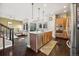 Open kitchen featuring a large island, stainless steel appliances, and sleek wooden cabinetry at 1857 W 67Th Pl, Denver, CO 80221